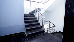 Un escalier moderne avec des rampes en métal et des marches noires.