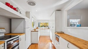 Una cocina moderna con armarios blancos, encimeras de madera y una isla central.