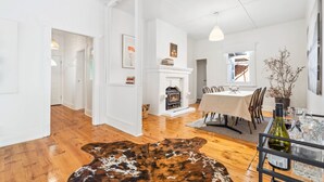 Una habitación amplia con chimenea, zona de comedor y vistas al exterior.
