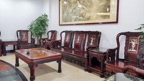 Une pièce au décor traditionnel, avec une table en bois, des chaises assorties et un grand tableau encadré accroché au mur.