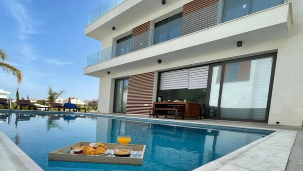 A modern two-story building with a swimming pool. - By the Beach Villa Natalya (Protaras)