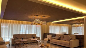 Een moderne woonkamer met banken, een salontafel en een kamerbreed tapijt met een patroon.