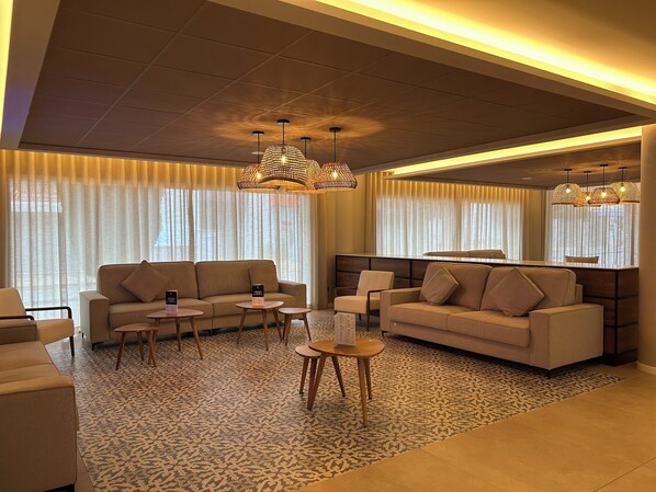 Una sala moderna con sofás, una mesa de centro y una alfombra estampada.