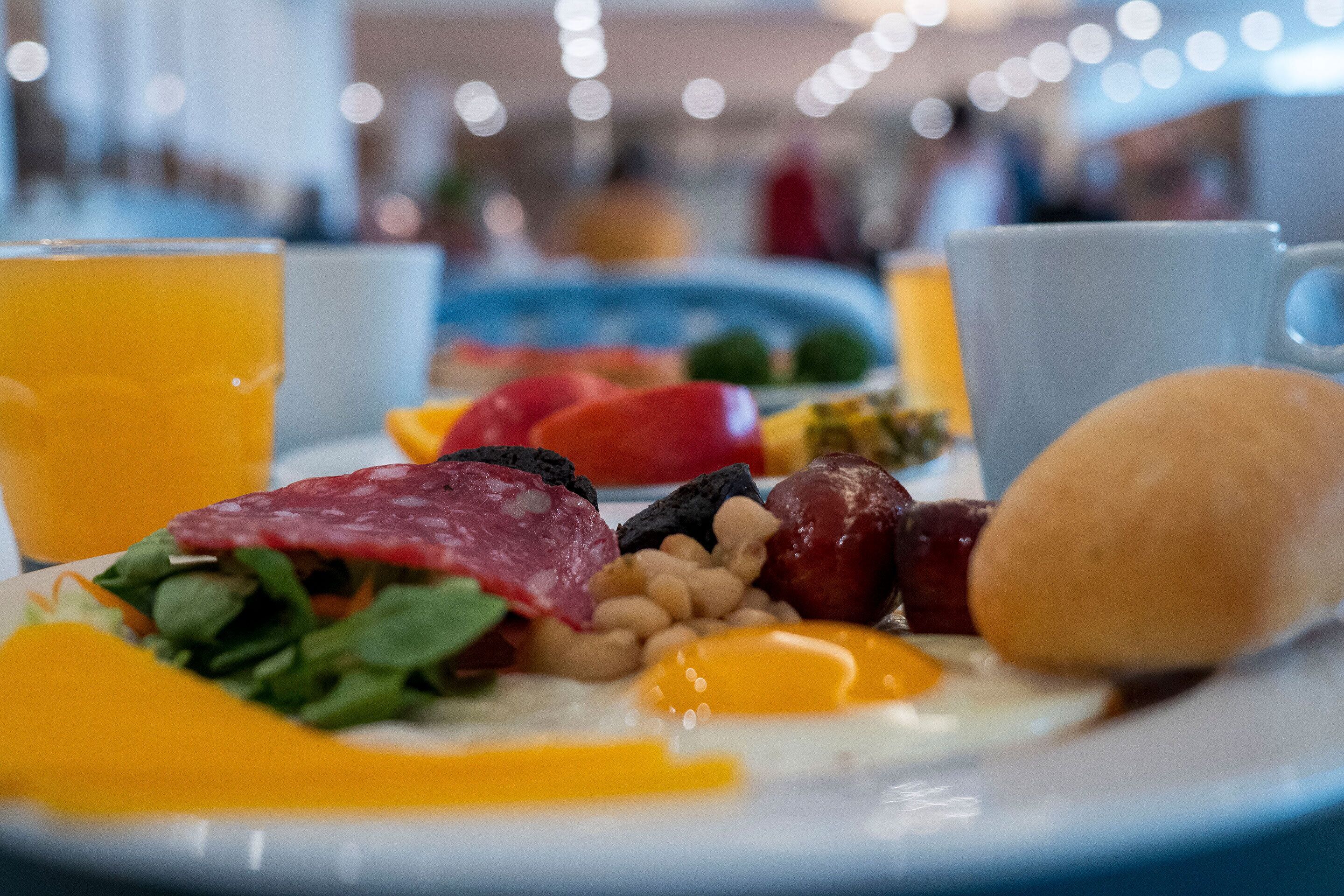 Un plato de desayuno con huevos, carnes y verduras.