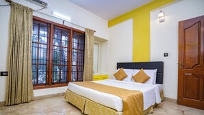 A neatly arranged bedroom with a bed, curtains, a window, and a door. - SS Mystic Apartotel (Bengaluru)