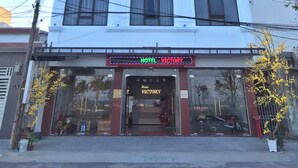 Un edificio de hotel de varios pisos con un letrero que dice "HOTEL VICTORY" en la parte superior.