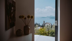 Ein Zimmer mit Blick auf ein Gewässer und entfernte Gebäude.