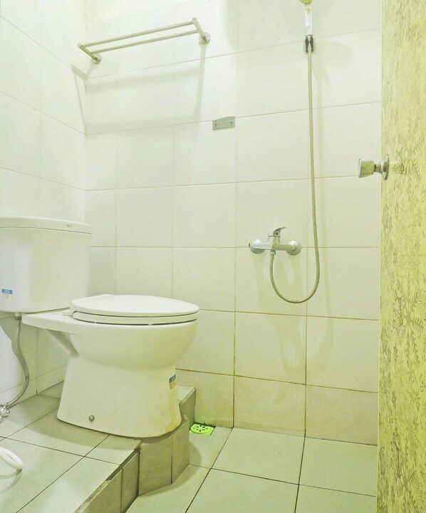 A bathroom with a toilet, a shower, and a handrail. - Hotel O Papi Inn Guesthouse (Palangkaraya)