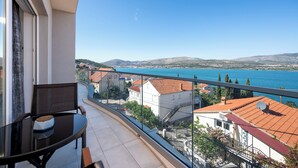 A balcony with a view of a body of water and surrounding buildings.