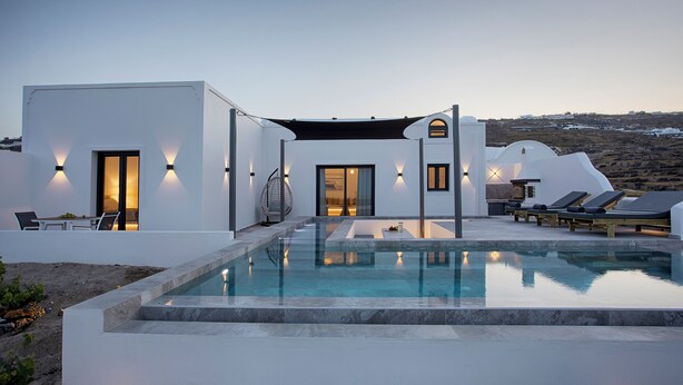 A modern villa with a swimming pool, outdoor seating, and a view of the landscape. - Vinebranch Villas (Santorini)