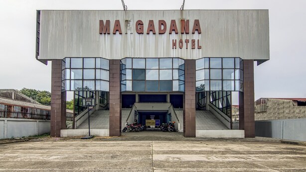 Exterior de l'Hotel Margadana, amb un disseny modern, que destaca per grans finestres de vidre i una entrada ben visible amb escales.