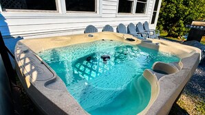 Ein Whirlpool mit Steinverkleidung, integriertem Sitz und einer Wasserpumpe.