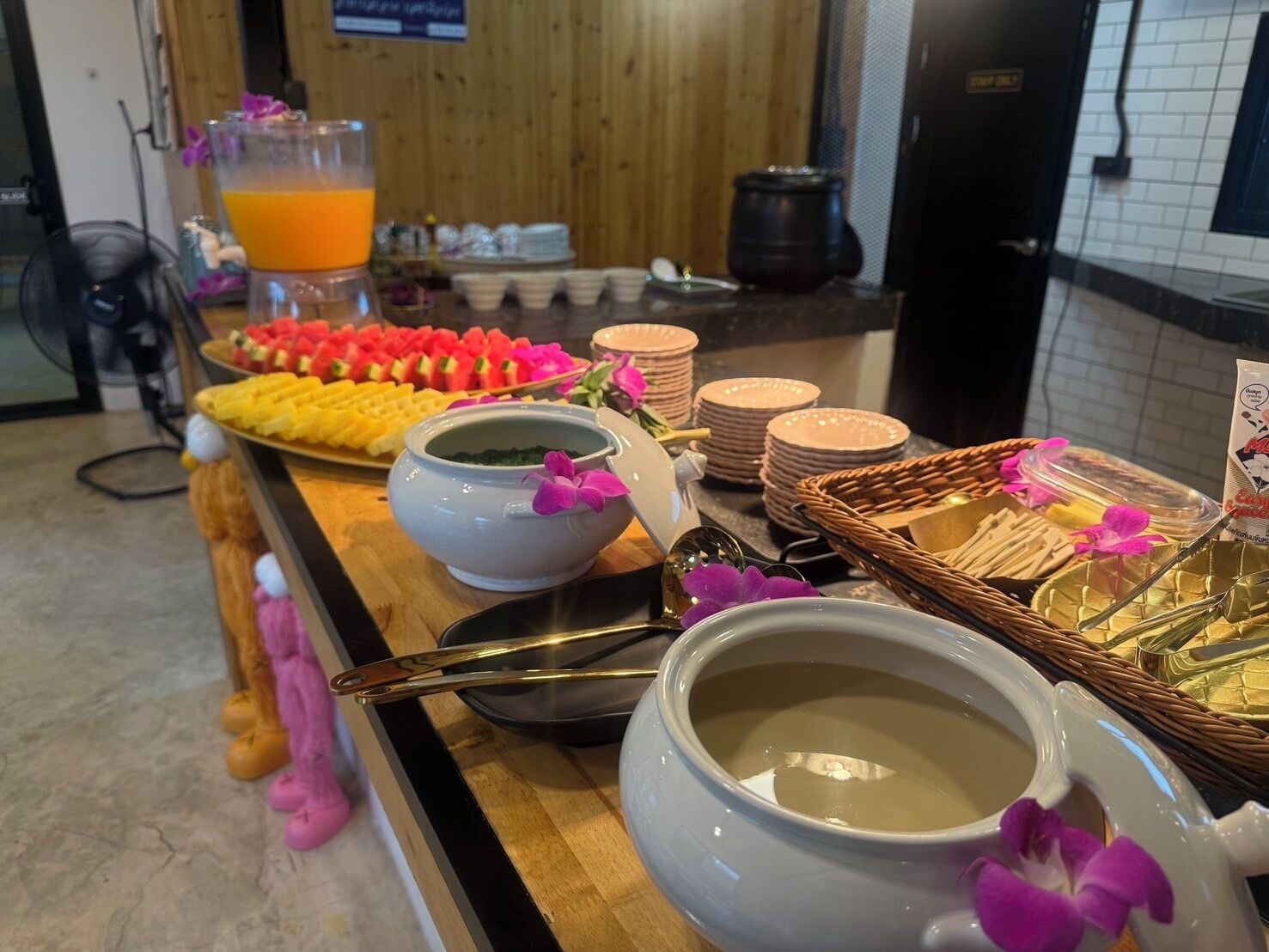 Ein Buffet mit verschiedenen Speisen, darunter Obst, Gebäck und eine Suppenschüssel.