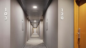 A hotel hallway with numbered doors, carpeted floors, and recessed lighting. - B&B Hotel Logroño Las Cañas (Viana)