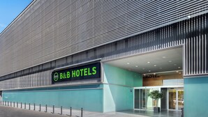 A modern B&B hotel with a prominent sign, a covered entrance, and a glass facade. - B&B Hotel Logroño Las Cañas (Viana)