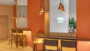 A modern bar area with wooden chairs and pendant lighting. - B&B Hotel Logroño Las Cañas (Viana)