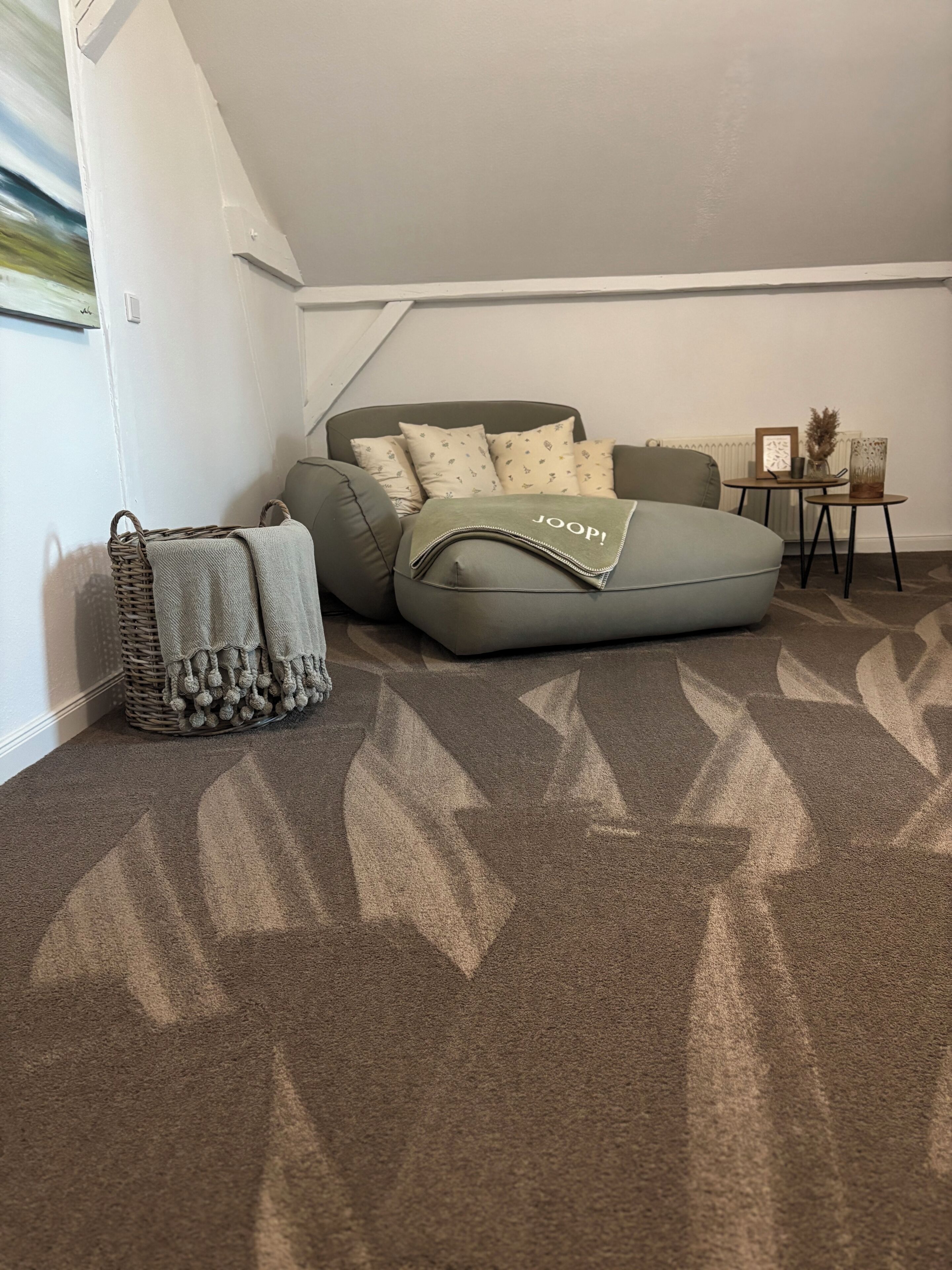Una habitación acogedora con un sofá modular, una mesita auxiliar pequeña y una cesta tejida.