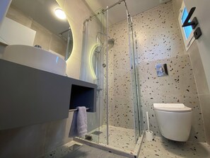 Een douche, handdoeken, zeep, shampoo