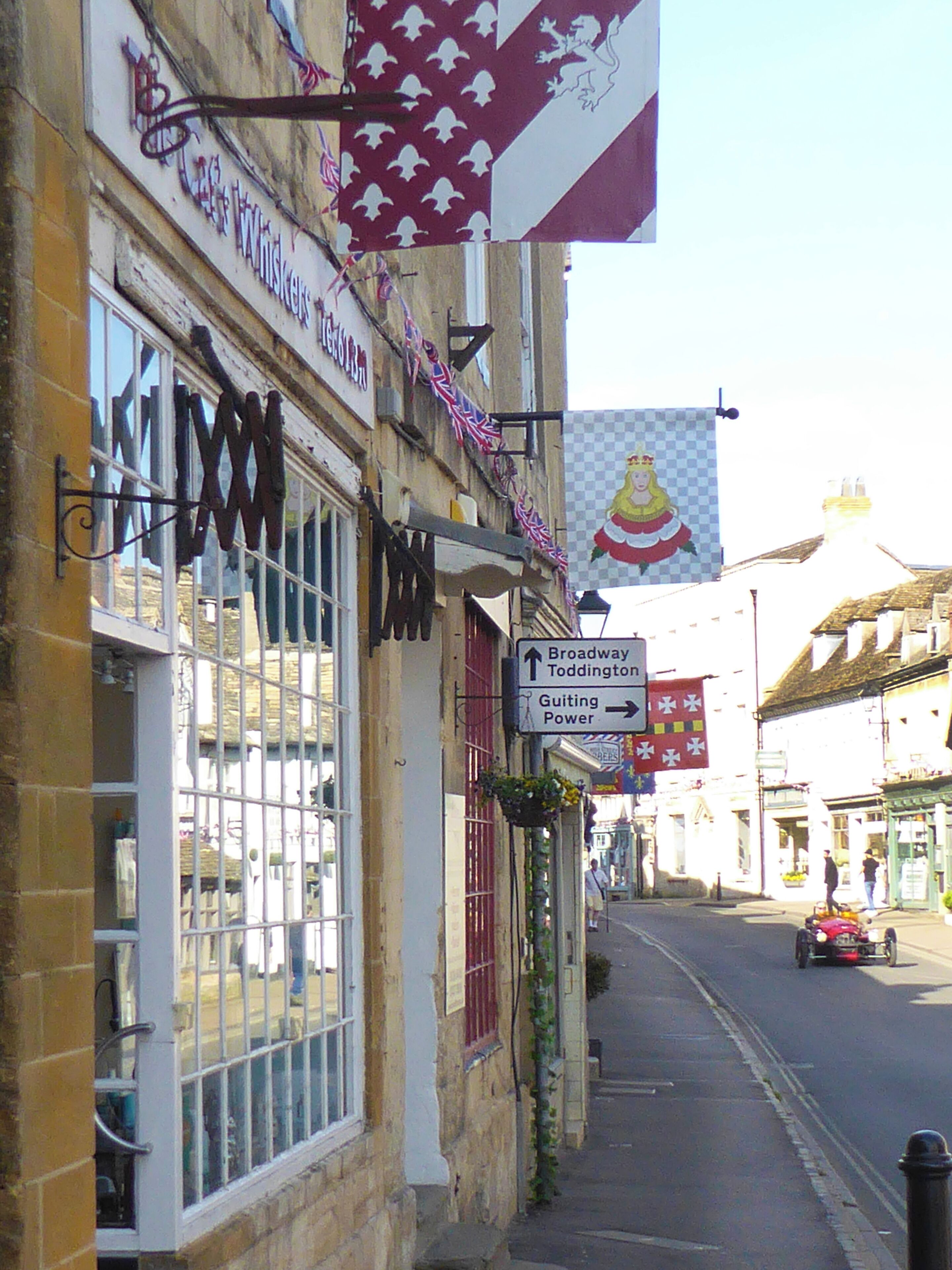 Une vue de rue avec un bâtiment portant l’inscription « MIXW » et une enseigne indiquant « Broadway Toddington ».