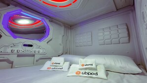 A modern room with a bed, a control panel, and a ceiling light fixture. - UBPOD capsule hotel in Mongolia (Ulaanbaatar)