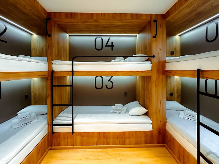 Habitación con literas, paredes de madera y camas numeradas.