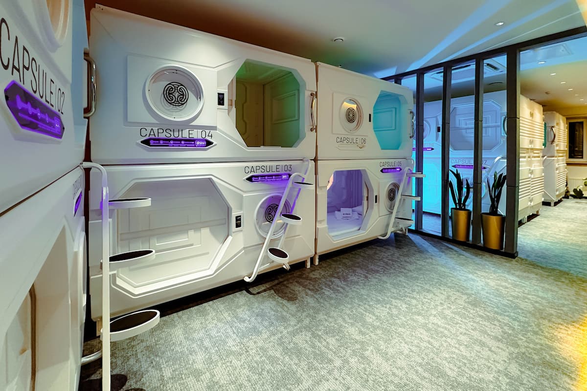 A row of capsule-style hotel rooms with a modern design, each labeled with a capsule number.