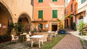 A courtyard with stone flooring, outdoor seating, and potted plants. - La Casa Nel Cuore di Sanremo, Historic Center (Sanremo)