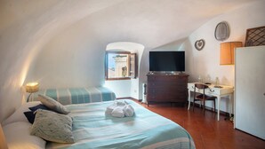 A bedroom with a bed, a desk, a television, and a window with a view. - La Casa Nel Cuore di Sanremo, Historic Center (Sanremo)