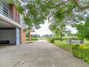 A residential property with a covered patio, a garage, and a landscaped garden with a seating area.