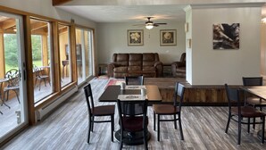 Une pièce spacieuse comprenant un coin repas, un canapé et un ventilateur de plafond.