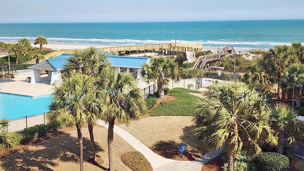 A resort with a swimming pool, palm trees, and a beach view. - Crescent D4E Litchfield Beach (Pawleys Island)