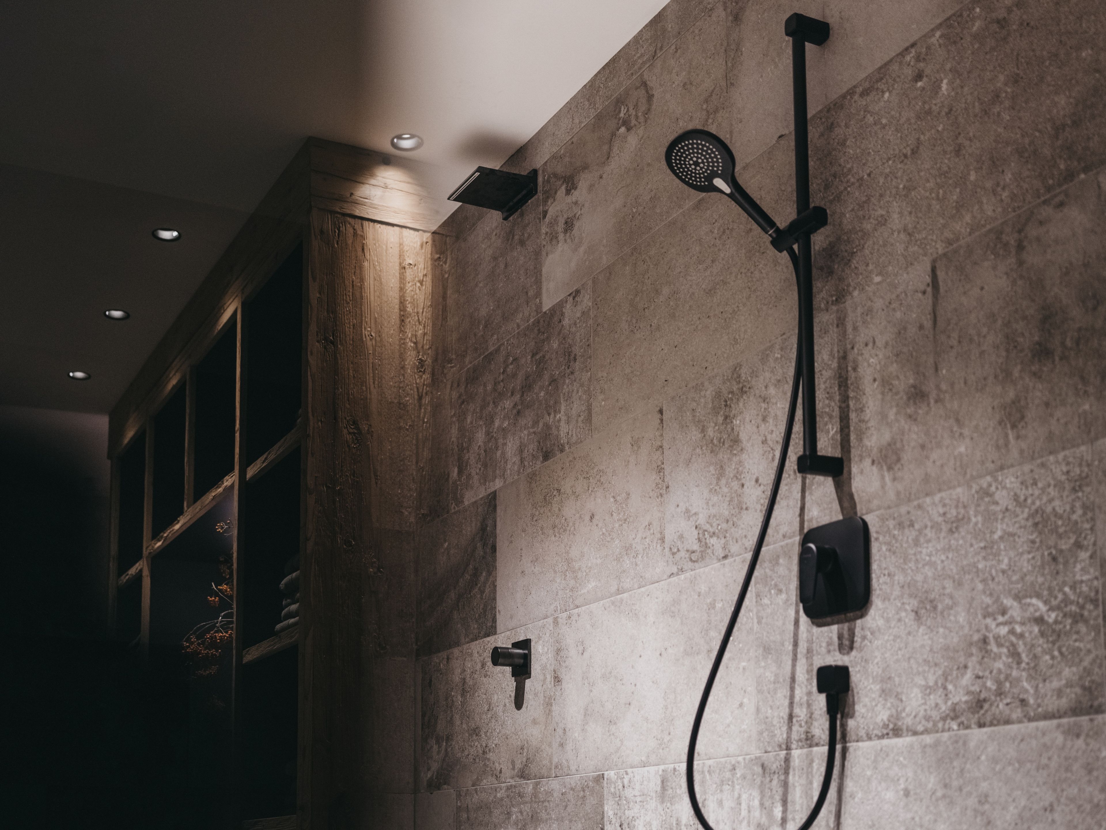 Une salle de bain équipée d’une douche, d’un porte-serviettes et d’un luminaire fixé au mur.