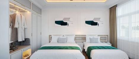 Une chambre d’hôtel moderne équipée de deux lits, d’une armoire et d’un ventilateur de plafond.