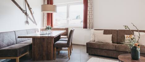 Ein modernes Wohnzimmer mit Holzesstisch, zwei Sofas und einem Couchtisch.