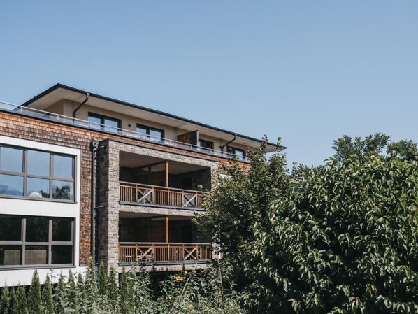 Un bâtiment moderne doté d’un balcon à deux étages et de grandes fenêtres.