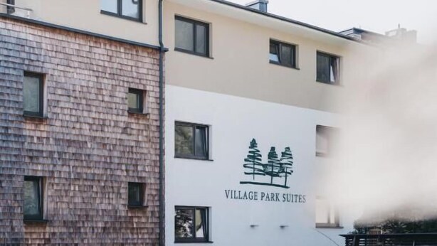 A building with a sign reading "Village Park Suites." - Village Park Suites (Zell am See)