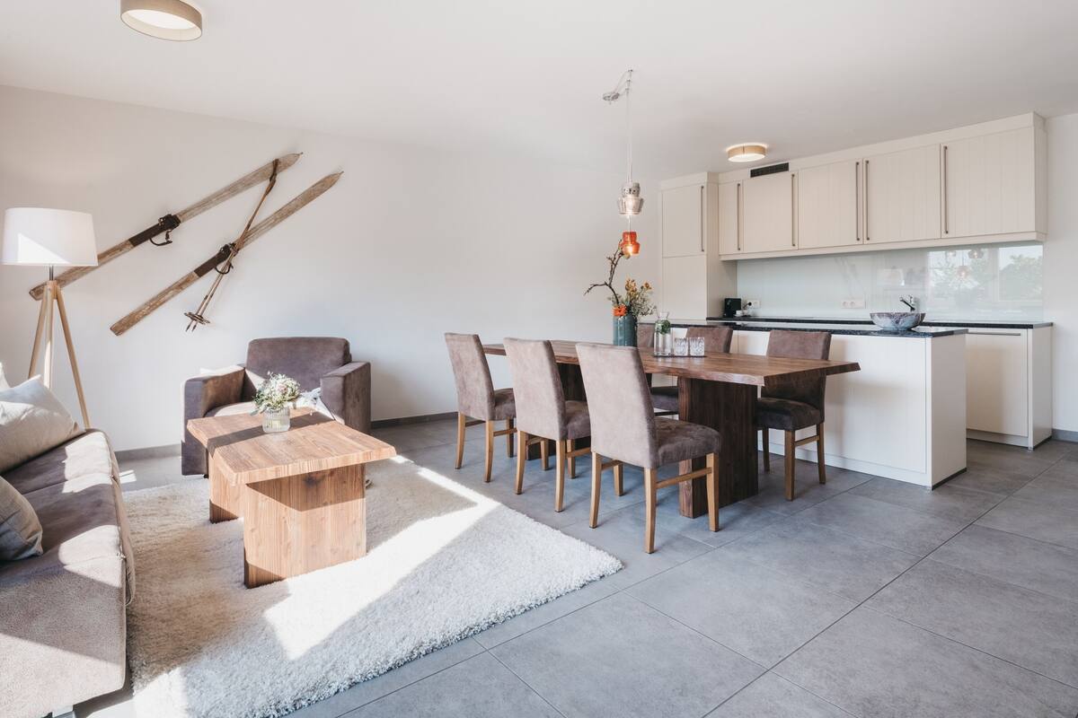 Un apartamento moderno con zona de comedor, cocina y sala de estar.