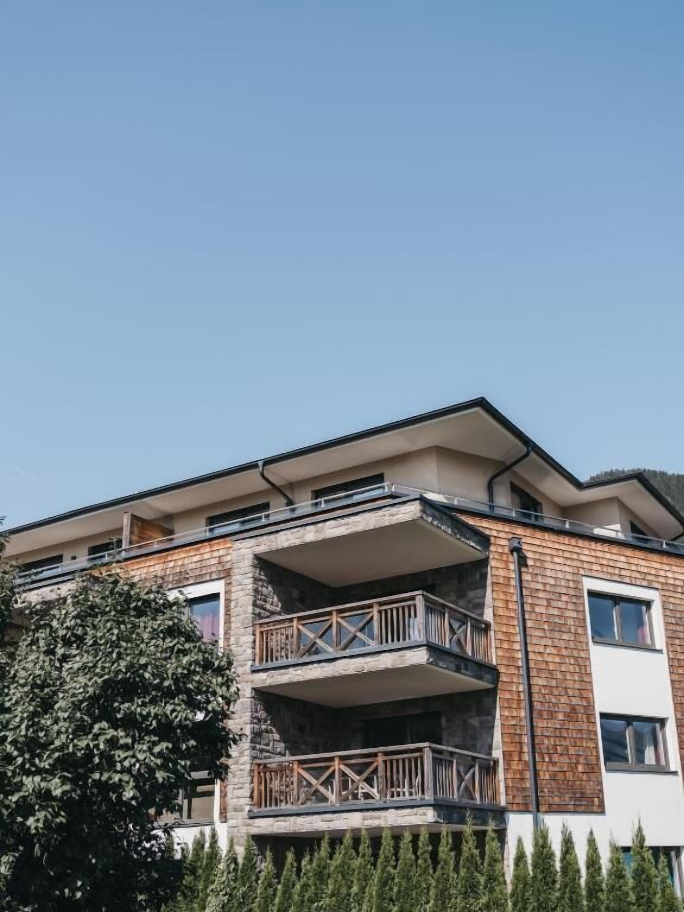 A multi-story building with balconies and a stone facade.