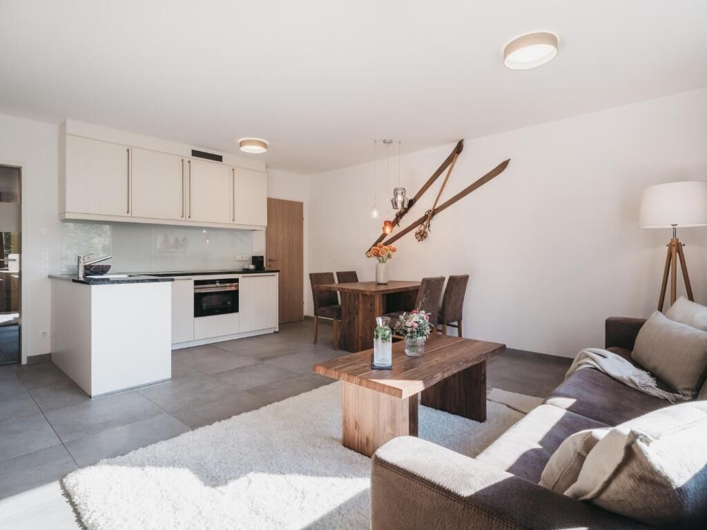 Een moderne woonkamer met een houten salontafel, een bank en een eethoek met een tafel en stoelen.