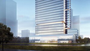 A modern high-rise building with a glass facade, labeled "ASCOTT," featuring a prominent entrance and a landscaped area in front.