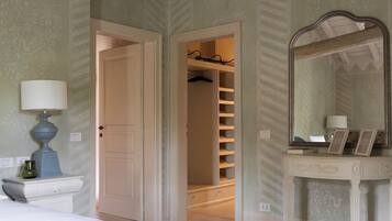Ein Schlafzimmer mit einem Bett, einem Schminktisch, einem Spiegel und einem begehbaren Kleiderschrank.