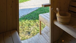Un interno in legno con una panca e un secchio di legno.