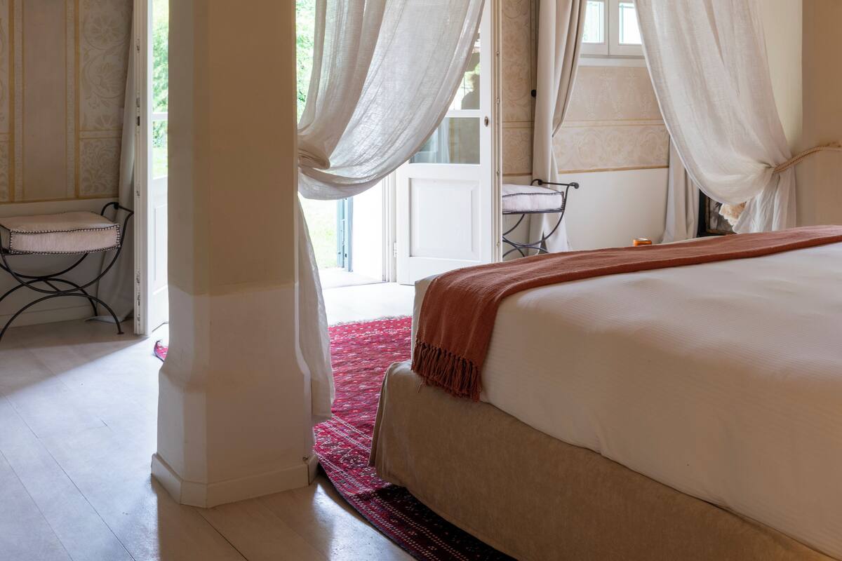 A bedroom with a large bed, a red carpet, and a brick ceiling.
