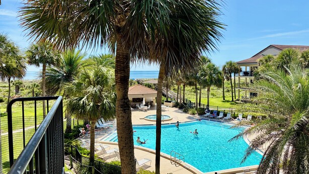 A swimming pool surrounded by palm trees and a view of the ocean. - Tropical getaway awaits!!! (Saint Augustine)