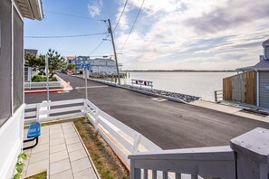 A waterfront property with a balcony, a view of the water, and a road leading to a dock. - House with Bayview, Walk to the Beach & Boardwalk (Ocean City)