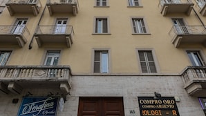 Un edificio de varios pisos con balcones, una tienda en la planta baja y un letrero que indica una joyería.