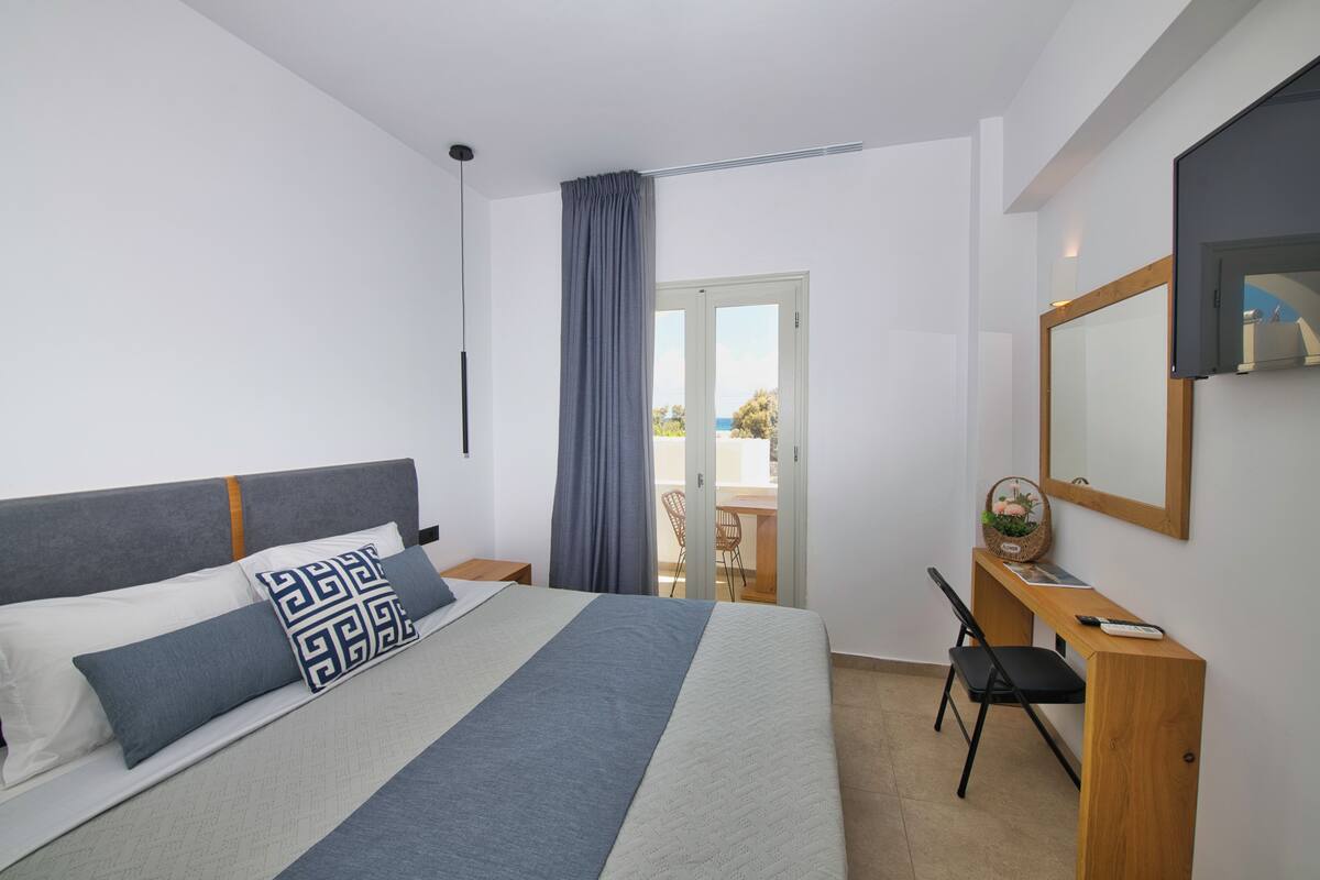 A modern bedroom with a bed, a desk, and a chair.