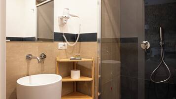 Eenvoudige tweepersoonskamer | Badkamer | Een haardroger, handdoeken, zeep, shampoo