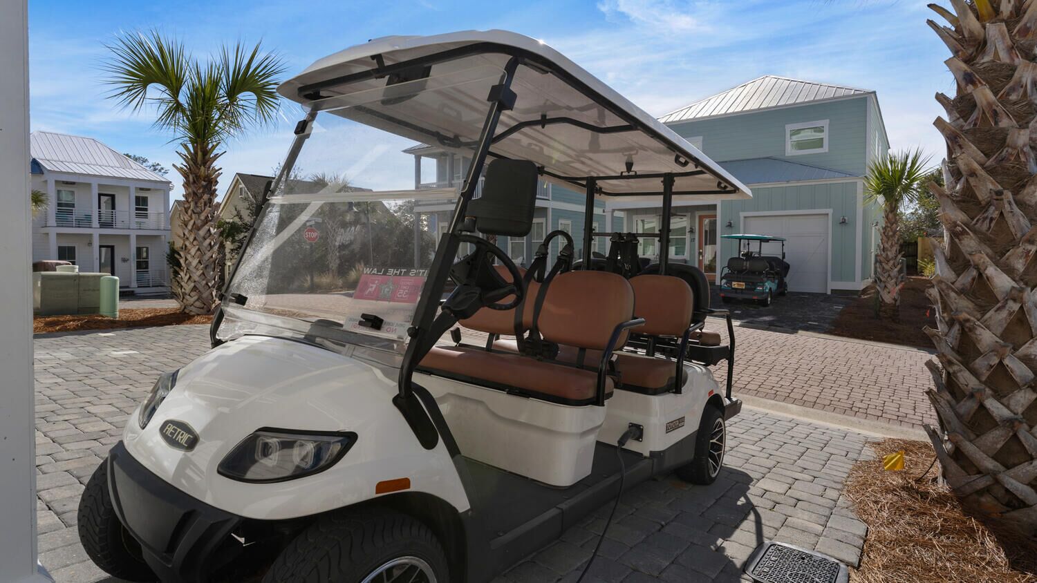 Ein Golfmobil steht auf einer Auffahrt, im Hintergrund ist ein Haus zu sehen.