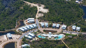 An aerial view of a resort with multiple buildings, roads, and a large swimming pool.